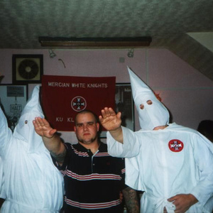 Der frühere »Blood & Honour« Aktivist Bernd P. aus Deutschland posiert vor einer Fahne der »MERCIAN White Knights of Ku Klux Klan« (England).