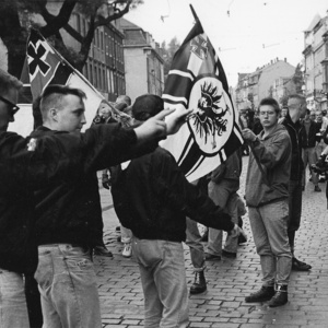 Der Neonazi und VS-Spitzel Kai Dalek (2.v.r.) mit Fotokamera und Ordnerbinde bei einer Neonazidemonstration 1991 in Dresden.